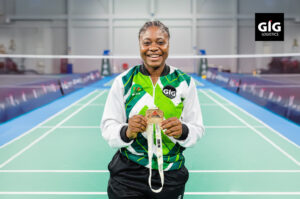 Eniola, Paralympics badminton champion holding her gold medal.
